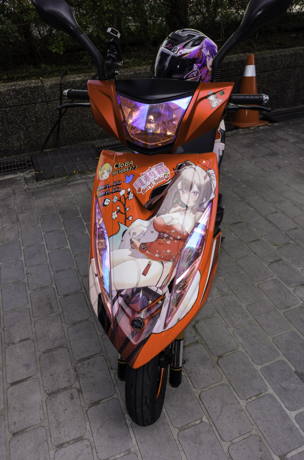 Ein oranges E-Scooter auf dem Seitenstreifen geparkt mit einem Helm darauf, mit einem Verkehrskegel, einer Wand und Bäumen im Hintergrund.