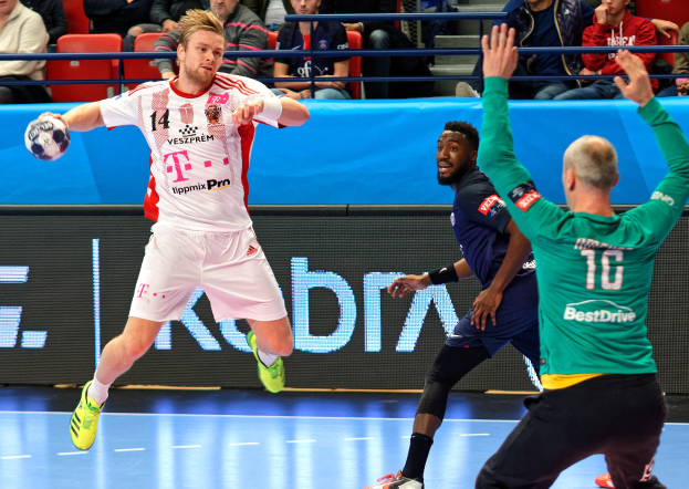 Mannergruppe spielt Handball auf einem Feld während des Futsal-Weltmeisterschaftsspiels 2019 zwischen Bayern München und Paris Saint-Germain, mit Zuschauern im Hintergrund.