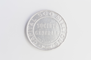 Eine Silbermünze auf einer weißen Oberfläche mit der Aufschrift 'Capital 500 Millionäre'.