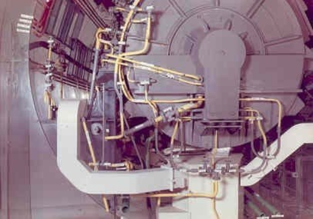 Großes industrielles Beschleunigergerät mit mehreren angeschlossenen Komponenten in einem Gebäude.