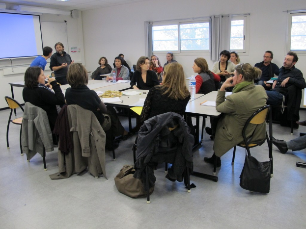 Eine Gruppe von Menschen, die sich unterhalten, wobei zwei Personen separat stehen und sprechen.