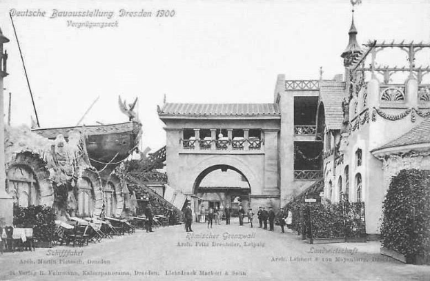 Schwarze und weiße Fotografie von Menschen, die eine Straße in Dresden, Deutschland im Jahr 1900 entlanggehen, mit Gebäuden, Pflanzen und Stühlen, die die Straße säumen und dem Himmel im Hintergrund.