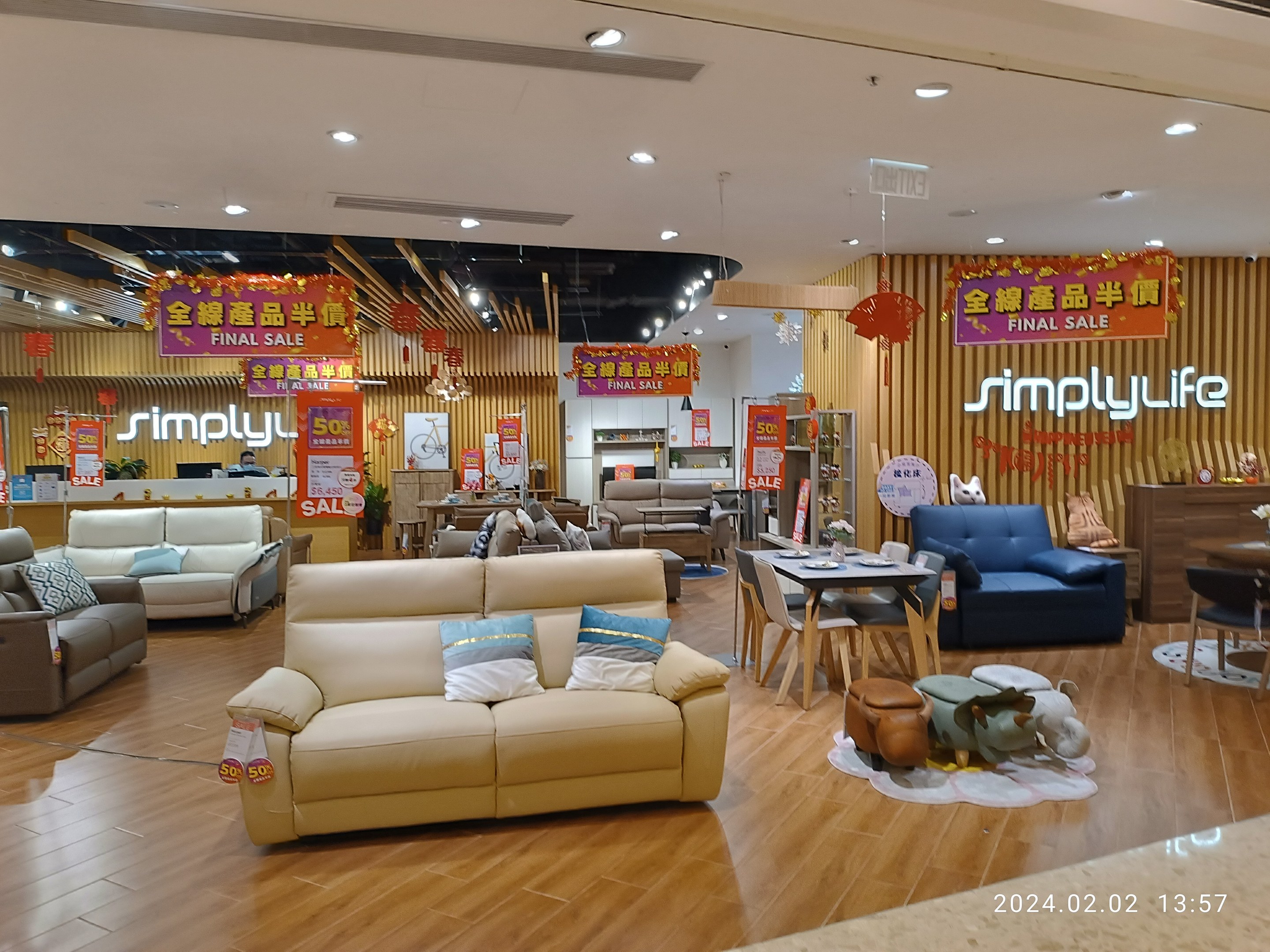 Ein Einrichtungshaus-Innenraum mit Sofas, Tischen, Stühlen, Hockern und anderen Gegenständen mit Deckenleuchten und Texttafeln in Chinesisch.
