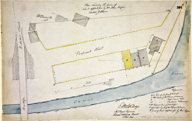 Ein detaillierter Papierplan des vorgeschlagenen Gebiets mit Straßen, Gebäuden und Sehenswürdigkeiten, begleitet von erklärendem Text.