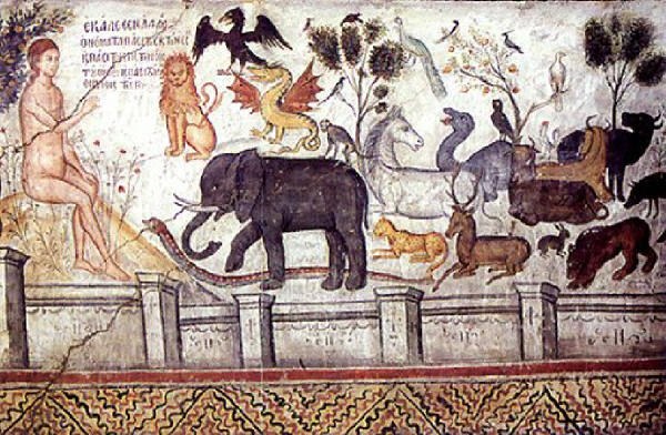 Fresko auf einer Wand eines Hauses in Pompeji, das eine Frau in einem wallenden Kleid mit ausgestreckten Armen zeigt, umgeben von einem Löwen, einer Giraffe, einem Zebra, einem Flusspferd, grünen Bäumen, fliegenden Vögeln und Schrifttext.